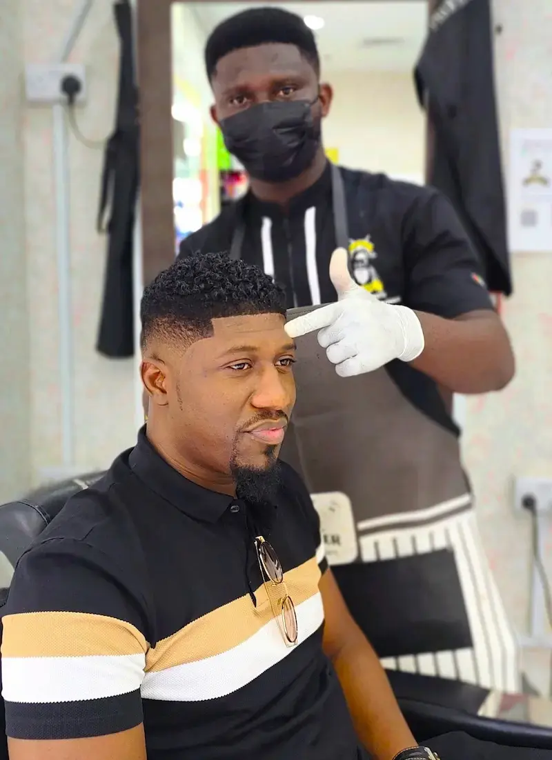 barber giving clean fade haircut to client at Kings Afro Barbershop in JVC Dubai