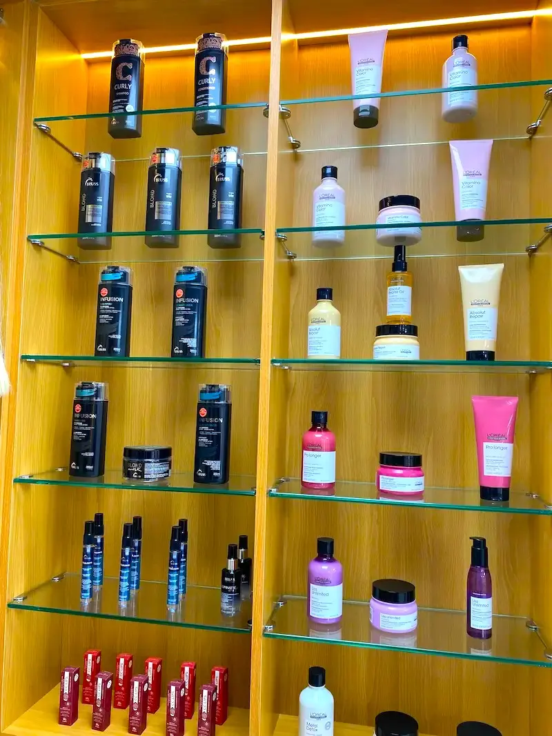 barber shop product display with hair care products on illuminated shelves at Kings Afro Barbershop JVC Dubai