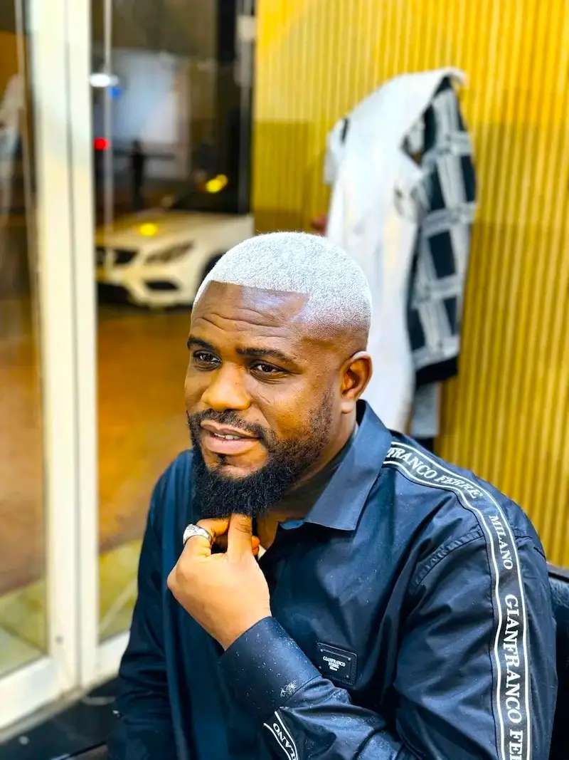 man with fresh haircut and beard sitting in barber chair inside Kings Afro Barbershop JVC Dubai